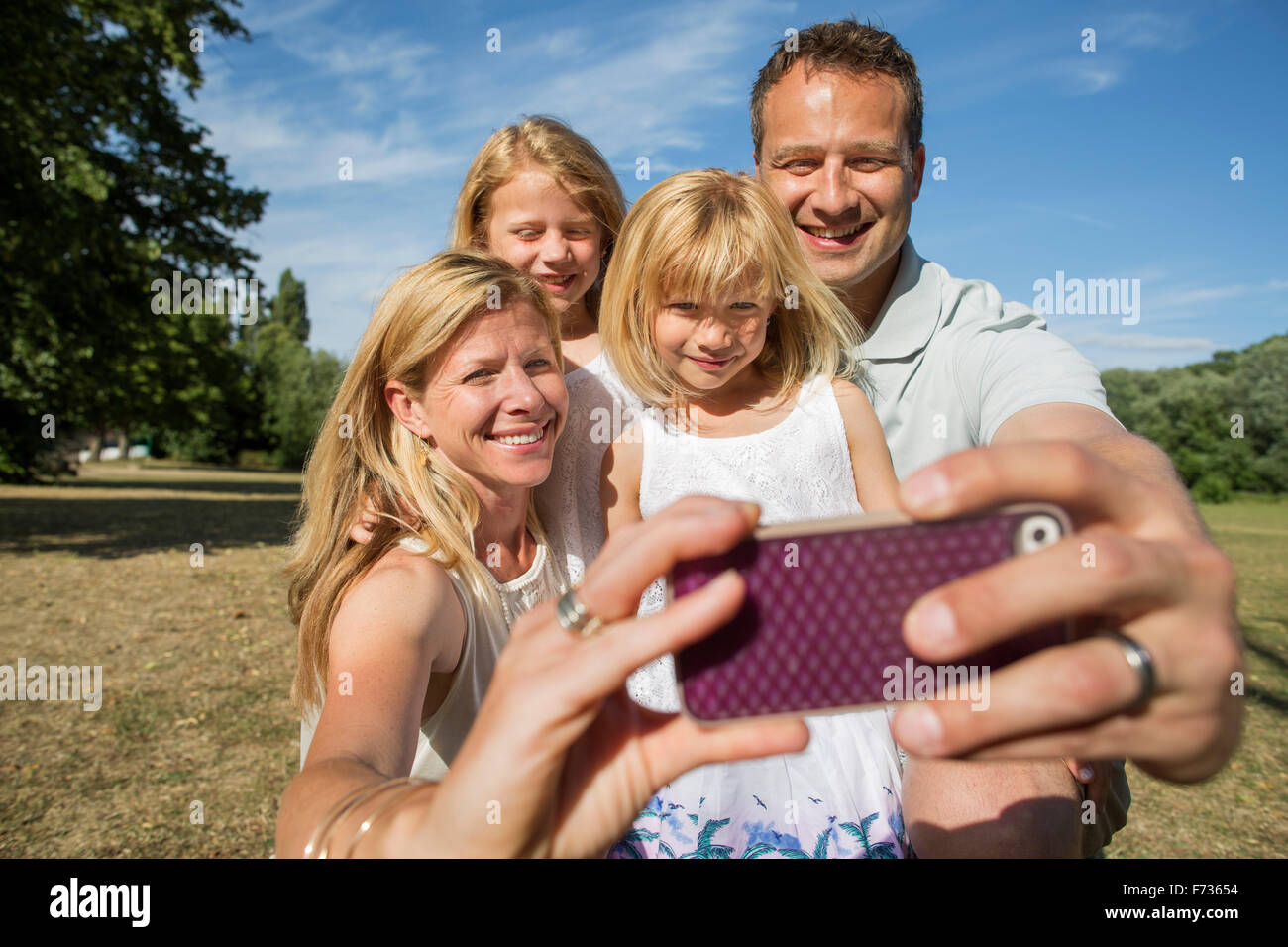 Famiglia con due bambini, prendendo un selfie. Foto Stock