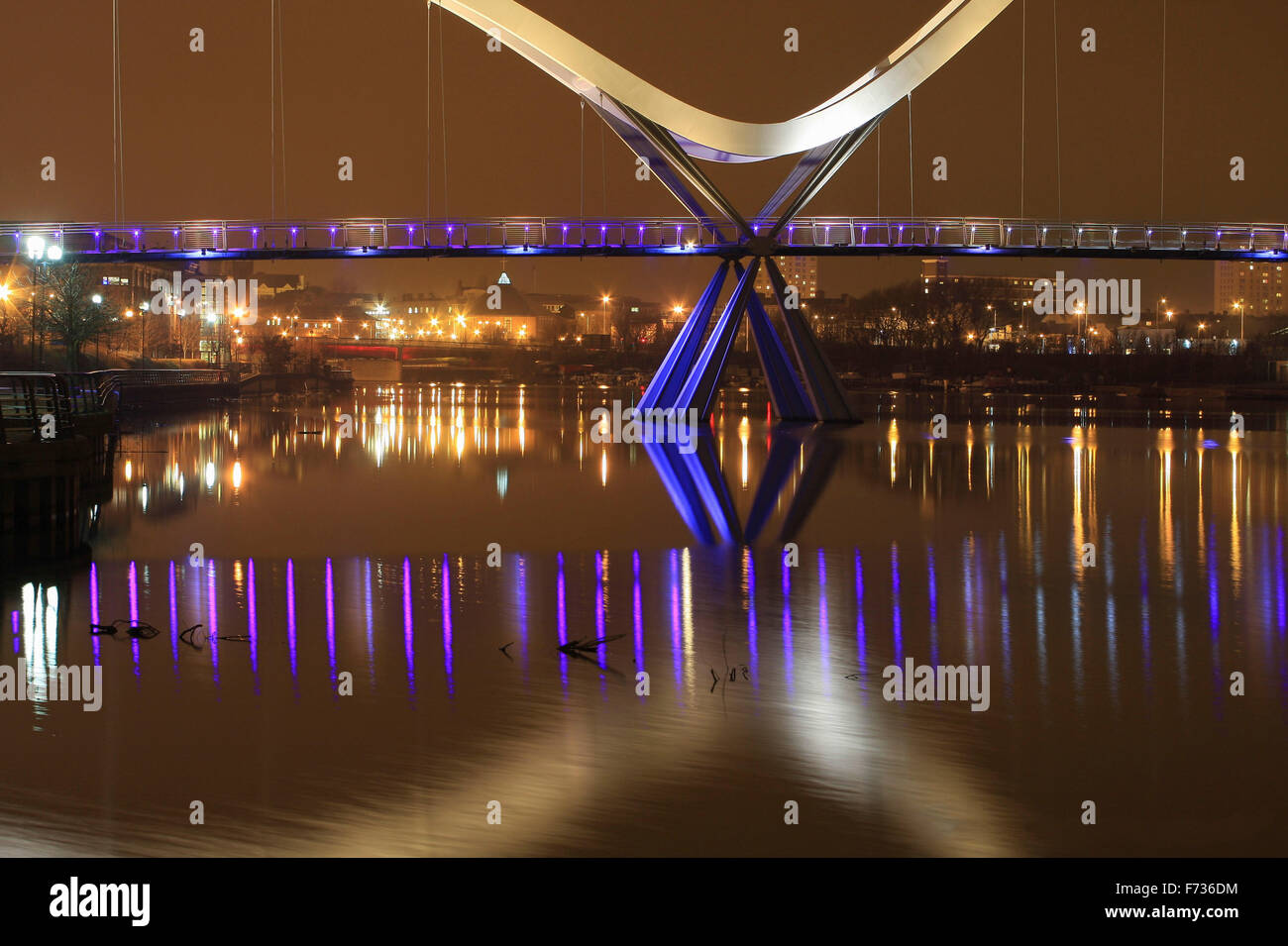 Illuminato Ponte Infinity di notte tempo in Stockton-on-Tees con centro in background e riflessioni sul fiume. Foto Stock