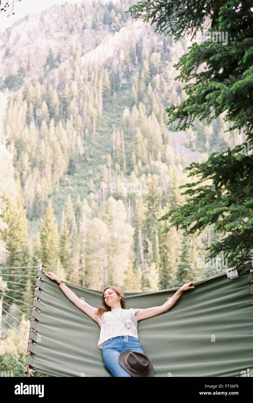 Donna rilassante in una grande amaca in una foresta. Foto Stock