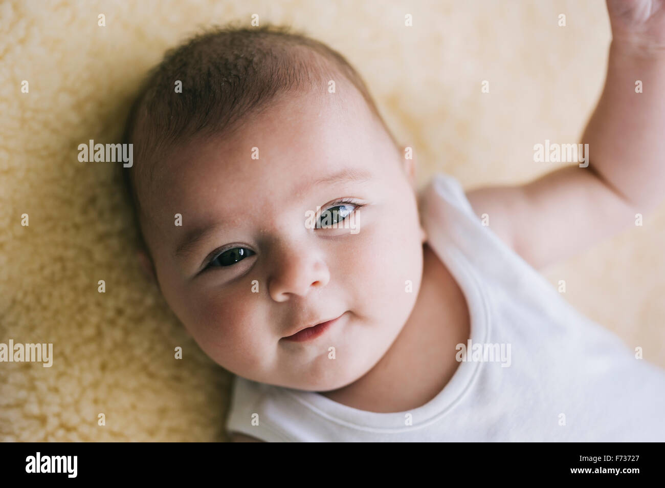 Una bambina sdraiata sulla schiena guardando verso l'alto. Foto Stock