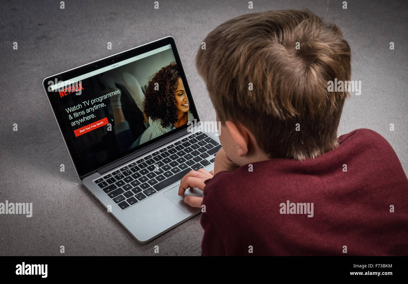 Un bambino guardando Netflix su un computer portatile Foto Stock