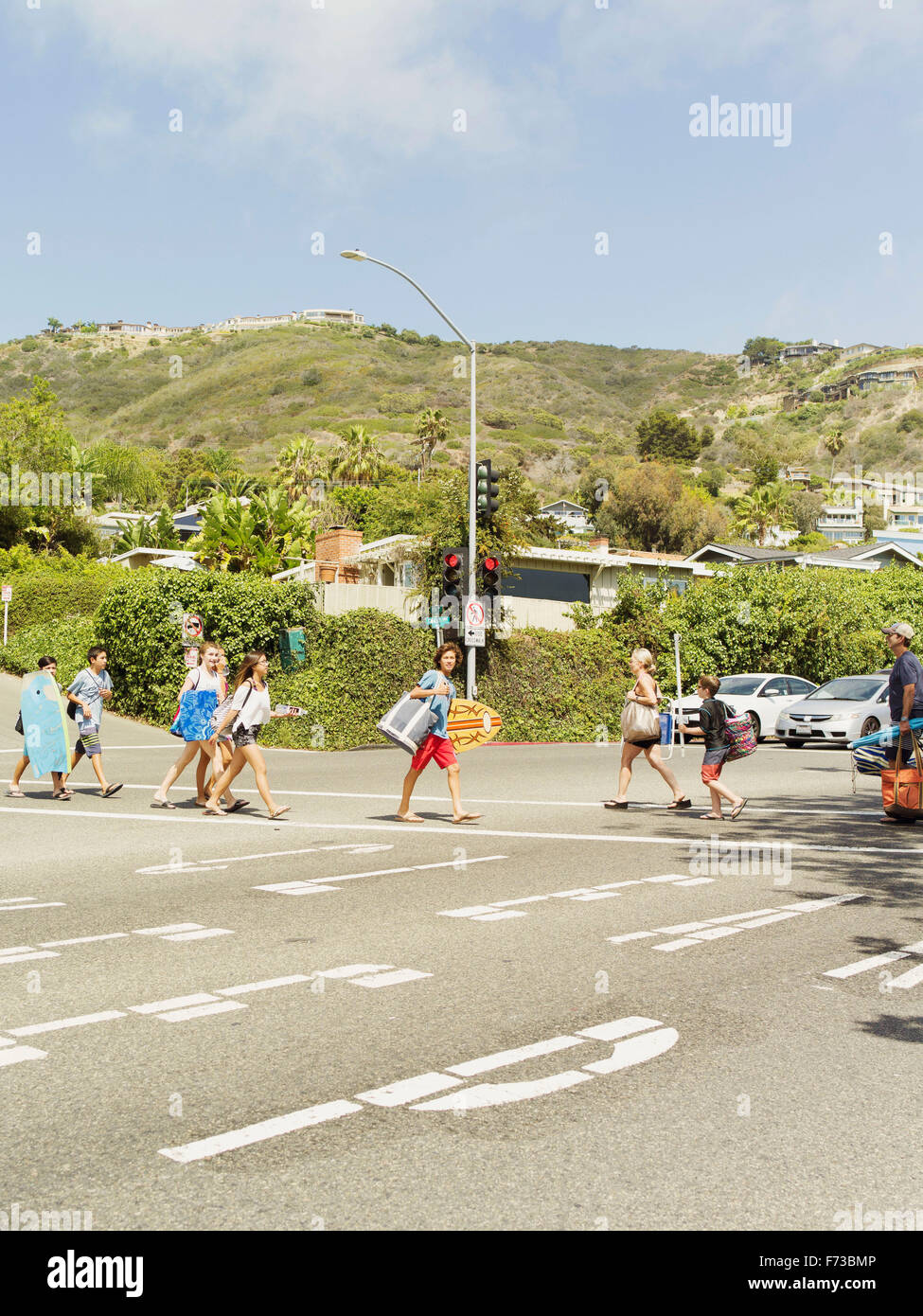 Frequentatori di spiaggia procedere a Laguna Beach in California con la tavola da surf, sdraio sulla spiaggia etc. Foto Stock