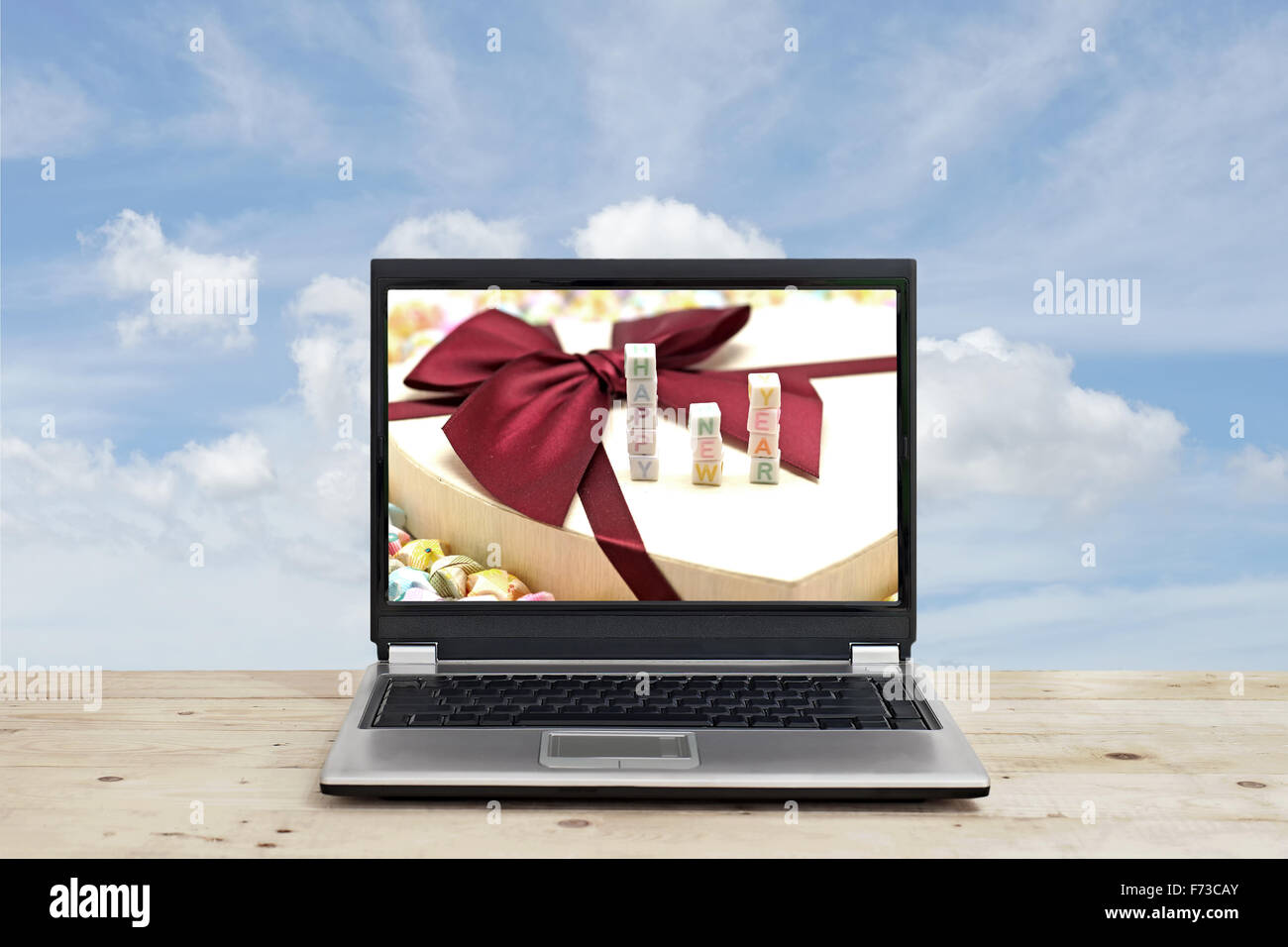 Parola felice anno nuovo su schermo di computer portatile con sfondo cielo Foto Stock