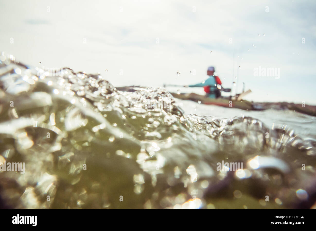 La metà sotto acqua Shot del kayak Angler Paddling contro il vento Foto Stock