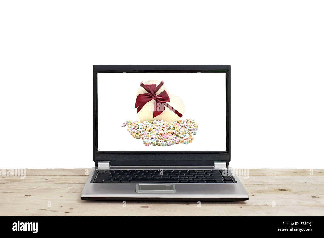 Confezione regalo e origami lucky stelle su schermo di computer portatile isolato su sfondo bianco Foto Stock