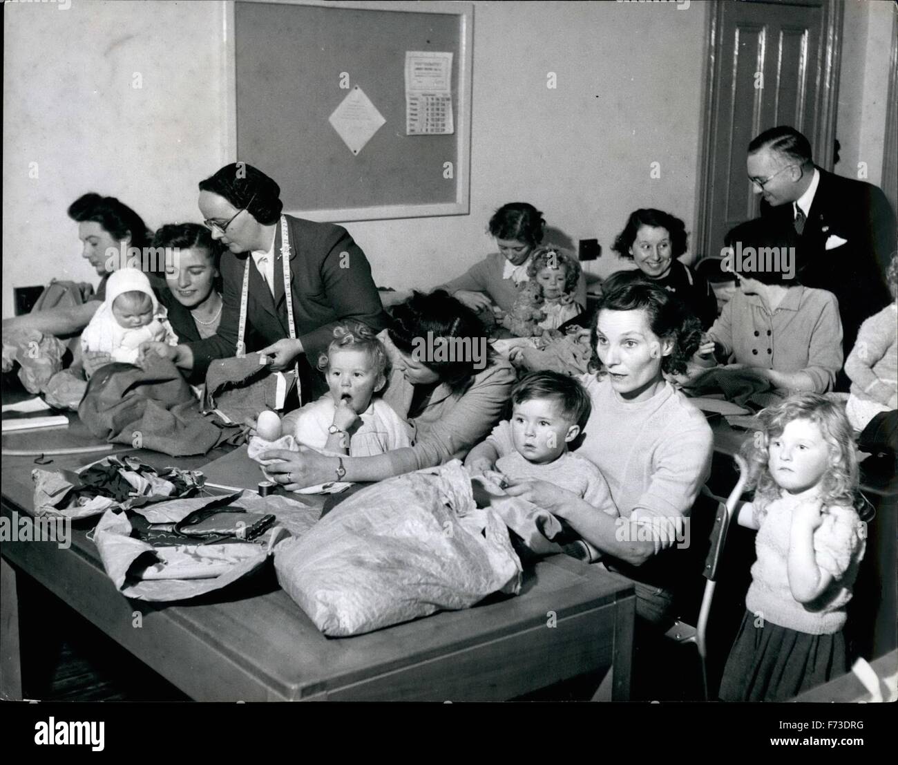 1956 - i bambini seduti con le loro madri durante il vestito-making classe. Miss H.A.Fricker, il Instructress fa il giro che offre aiuto e consulenza, mentre il preside del Collegio, il sig. G.H.Tweddell ha schioccato in per vedere come vanno le cose. Le madri portano i loro bambini per sartoria Classi: quando le giovani madri di Dover ha detto il sig. G.H.Tweddell, testa di Dover Collegio Tecnico che non hanno potuto partecipare al pomeriggio le classi di sartoria perché loro riuscivano a ottenere nessuno di occuparsi dei loro figli ha detto ''portare i bambini con te". Questo ardito esperimento si è dimostrata del tutto soddisfacente e ora Foto Stock