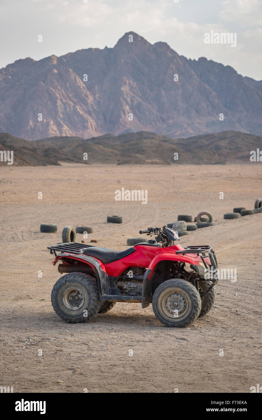 ATV moto quad nel deserto e bellissimo sfondo stone mountain. Foto Stock