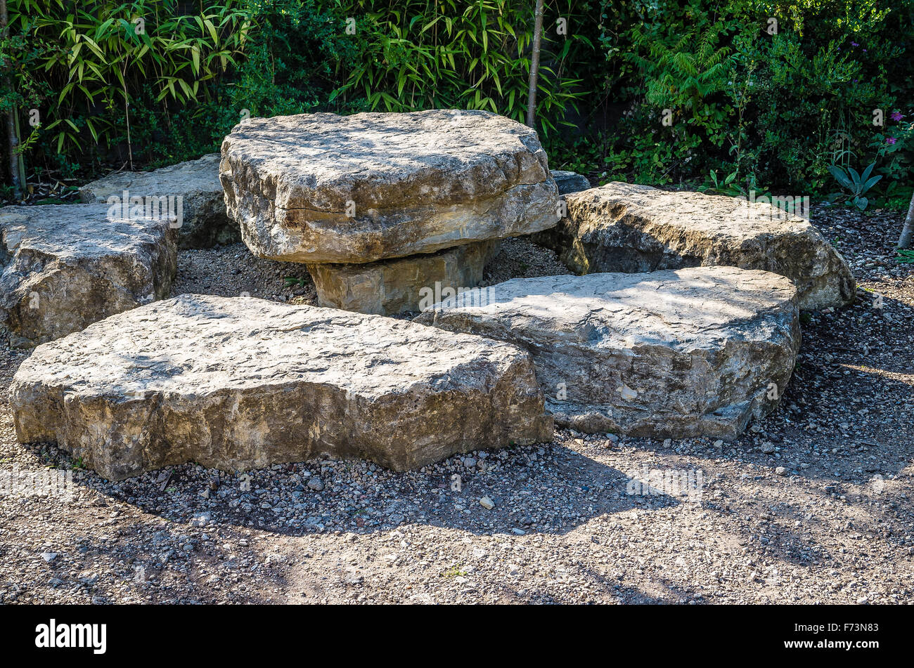 Lastre di pietra disposti a fornire posti a sedere informali in un bosco giardino Foto Stock