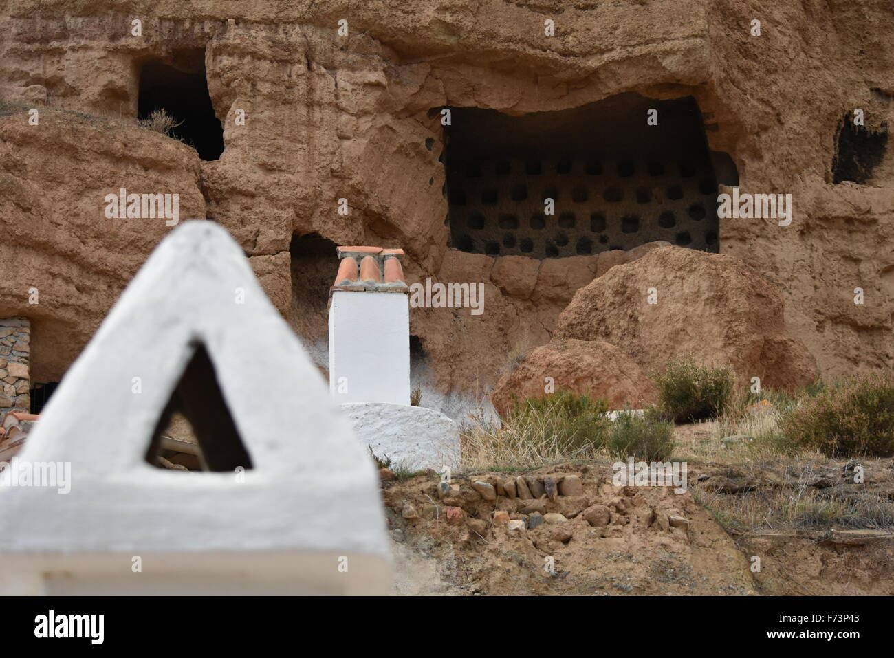 Rusty camini in grotte di Guadix, Granada, Spagna Foto Stock