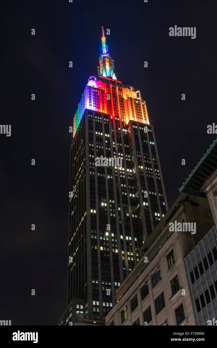 Notte a basso angolo di vista dell'Empire State Building con i colori dell'arcobaleno, Manhattan, New York, Stati Uniti d'America Foto Stock