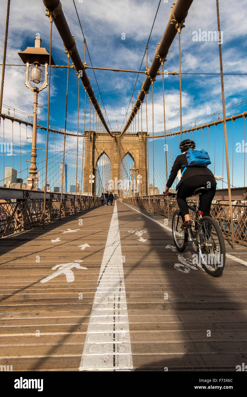 Ciclista in sella la sua bici sul ponte di Brooklyn, New York, Stati Uniti d'America Foto Stock