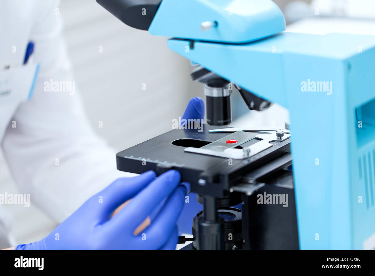 Stretta di mano con microscopio e campione di sangue Foto Stock