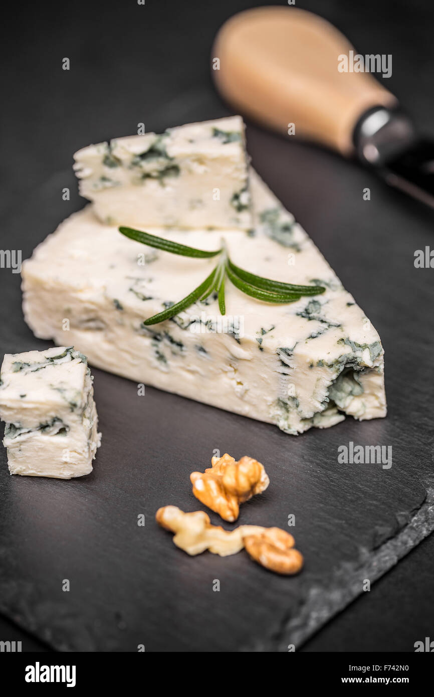Gustoso formaggio blu con il dado sul buio superficie di ardesia Foto Stock