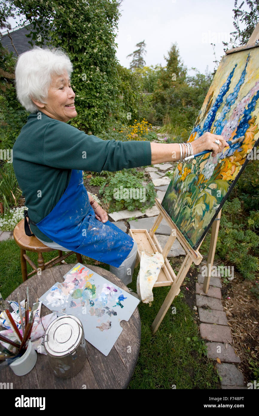 Anziani artista pittura in giardino Foto Stock