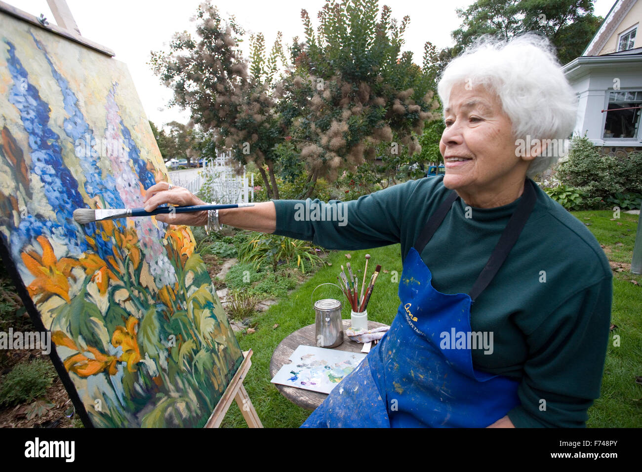 Anziani artista pittura in giardino Foto Stock