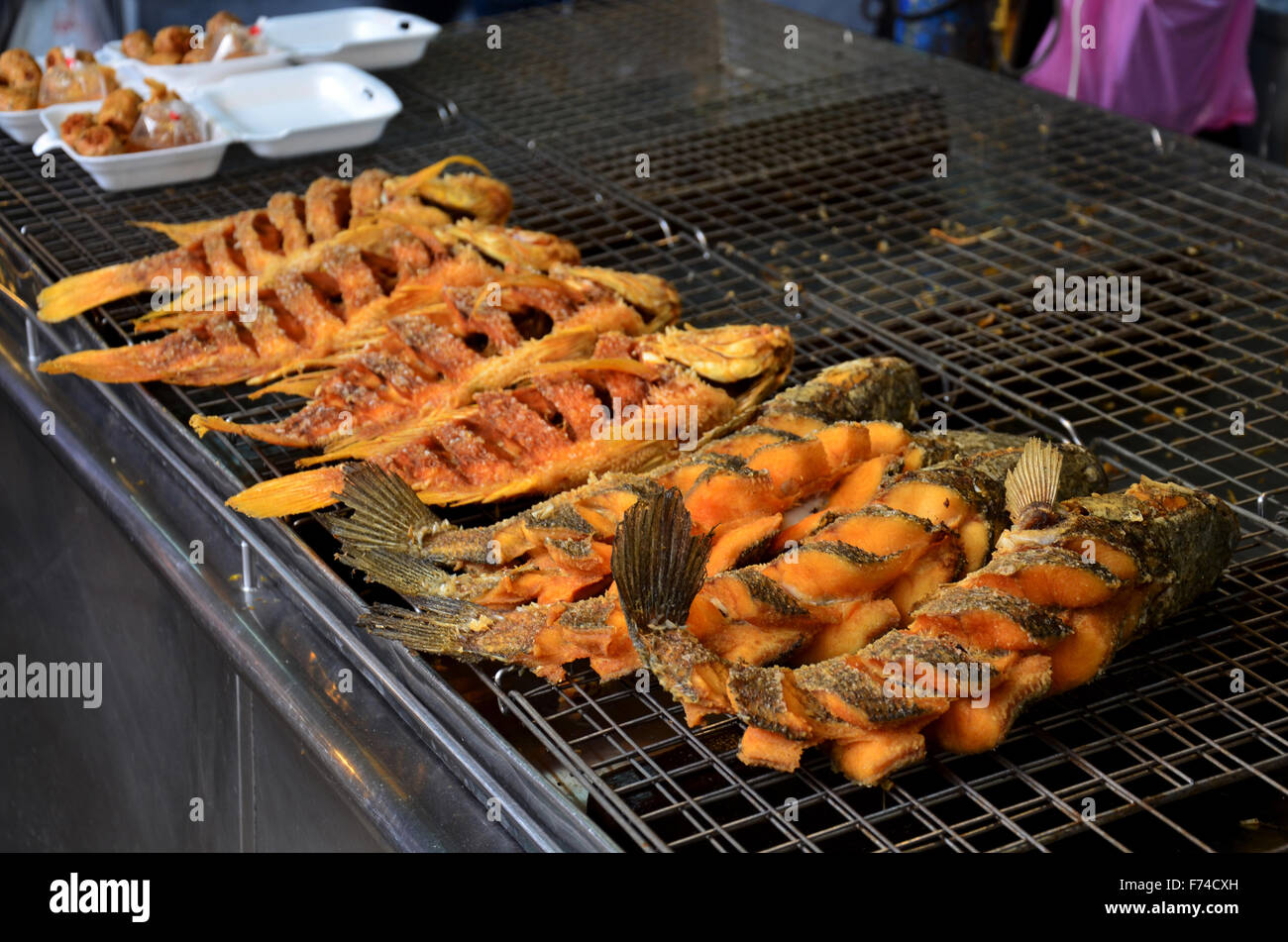 Snake-testa pesci fritti e Tilapia pesci fritti in vendita a Don Wai Mercato galleggiante in Nakhon Pathom, Thailandia. Foto Stock