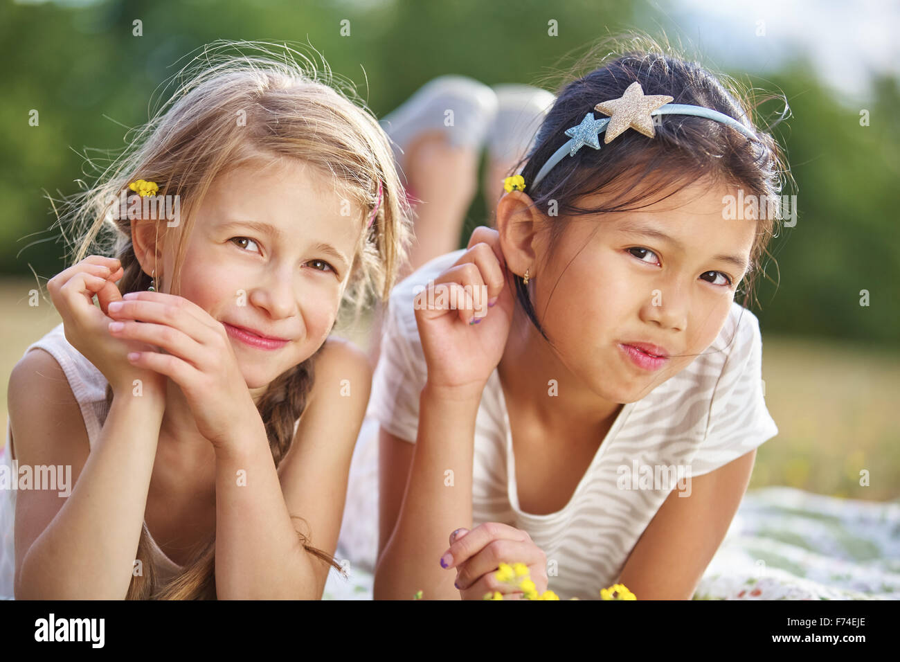 Due ragazze felici con fiori su i loro capelli in estate Foto Stock