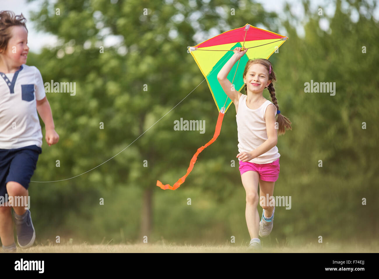 Ragazzo e una ragazza volare un aquilone e havin fun Foto Stock