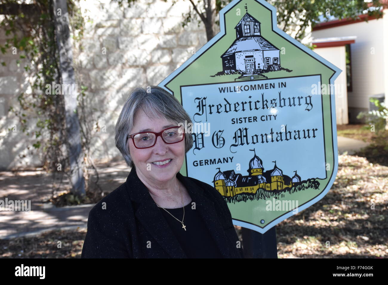 Il sindaco di Fredericksburg in Texas, Linda Langerhans, sorge nella parte anteriore di un segno storico di Fredericksburg, Stati Uniti d'America, 27 ottobre 2015. Fredericksburg è una delle ultime città in Texas, dove texano tedesco è ancora parlato, per la sua storia di immigrati tedeschi. Foto: Chris Melzer/dpa Foto Stock