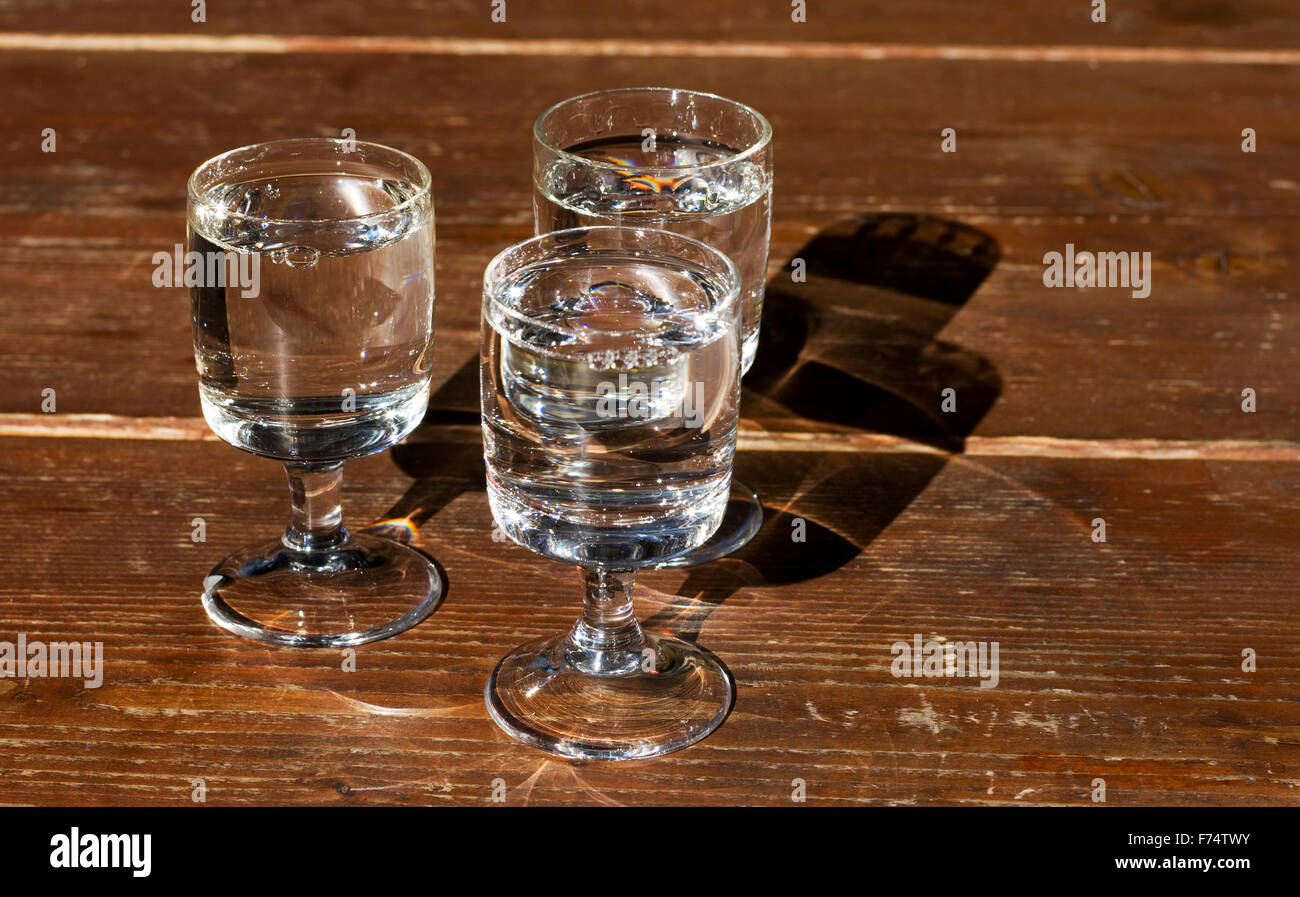 Foto di tre piccoli bicchieri pieni di spirito di alcole Foto Stock