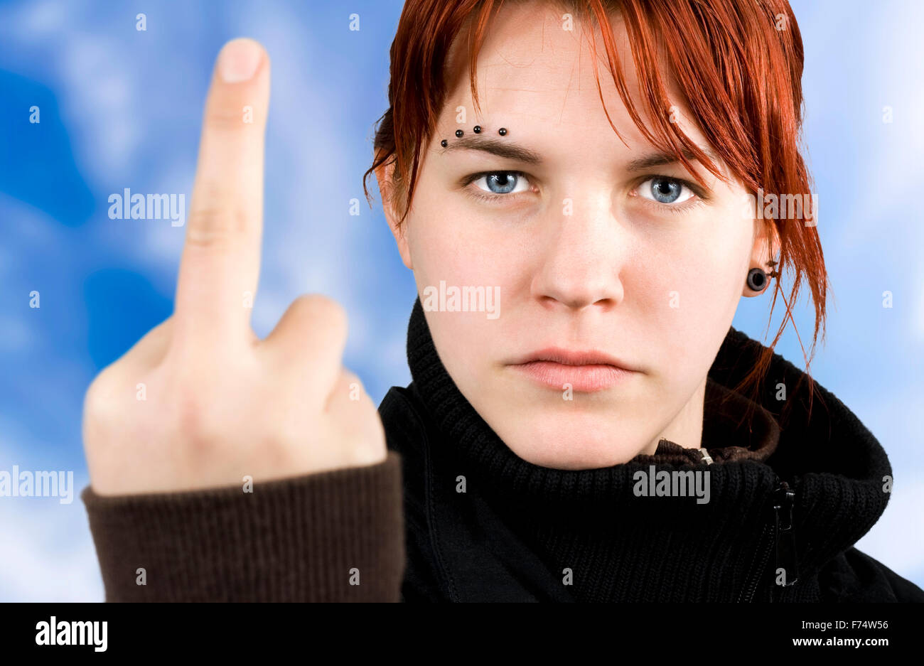 Ragazza arrabbiato che mostra il dito medio Foto Stock