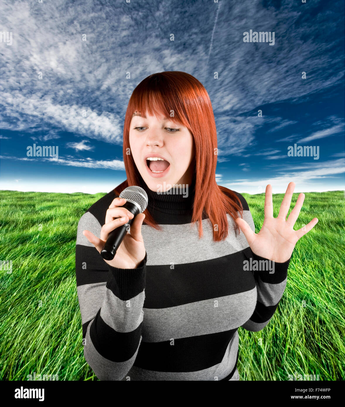 Redhead girl cantare karaoke sul microfono Foto Stock