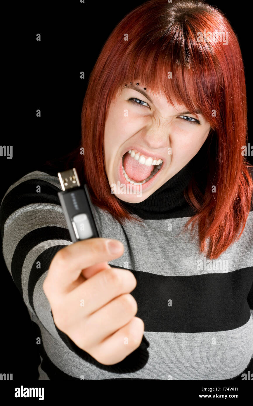 Redhead ragazza con un flash drive in telecamera Foto Stock