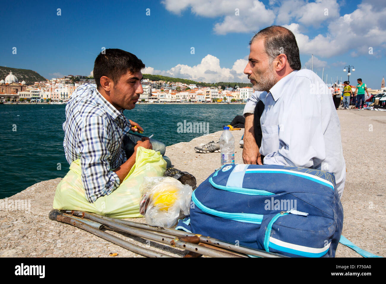 Un disabili migranti siriano che ha fuggito la guerra e sono scappati in Europa, atterraggio sull'isola greca di Lesbo sulla costa nord a Efthalou, è aiutato dalla polizia greca. Fino a 4 mila migranti un giorno sbarcano sull isola e schiacciante le autorità. Essi sono traficked illegale dal popolo turco i trafficanti che carica fino a 2.000 dollari a persona per mezza ora di viaggio in un sovraffollamento inflateable barca dalla terraferma turco a Lesbo. Foto Stock