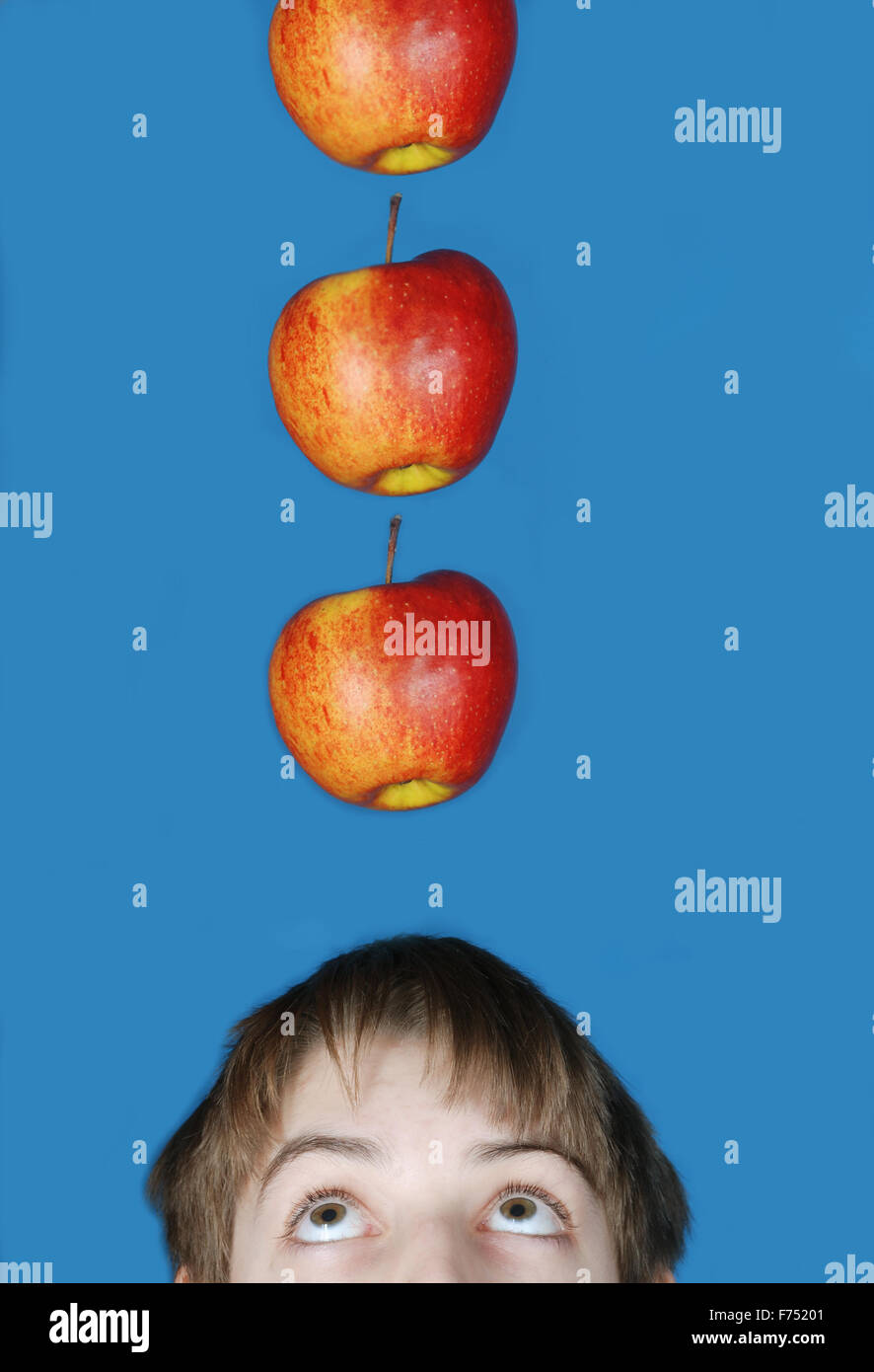 Una mela che cade sul ragazzo del capo Foto Stock