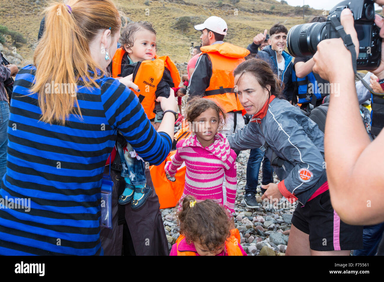 Gli immigrati siriani che fuggono dalla guerra e la fuga verso l'Europa, lo sbarco nell'isola greca di Lesbo sulla costa nord a Efthalou e aiutato da terra da volontari. Fino a 4 mila migranti un giorno sbarcano sull isola e schiacciante le autorità. Essi sono traficked illegale dal popolo turco i trafficanti che carica fino a 2.000 dollari a persona per mezza ora di viaggio in un sovraffollamento inflateable barca dalla terraferma turco a Lesbo. Foto Stock