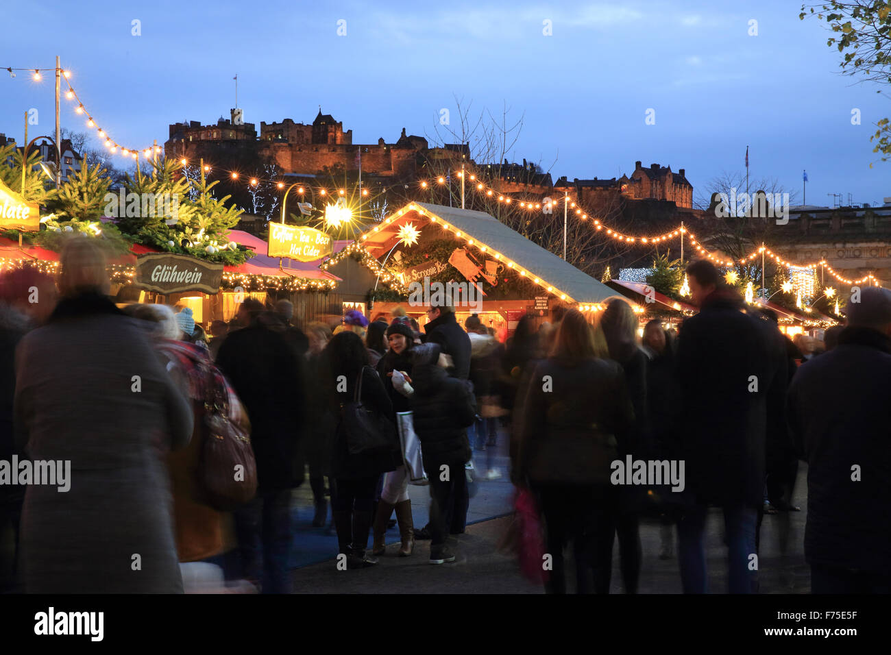 Edinburgh Mercatino di Natale nella zona est di Princes Street Gardens, con il castello dietro, al tramonto, in Scozia, Regno Unito Foto Stock