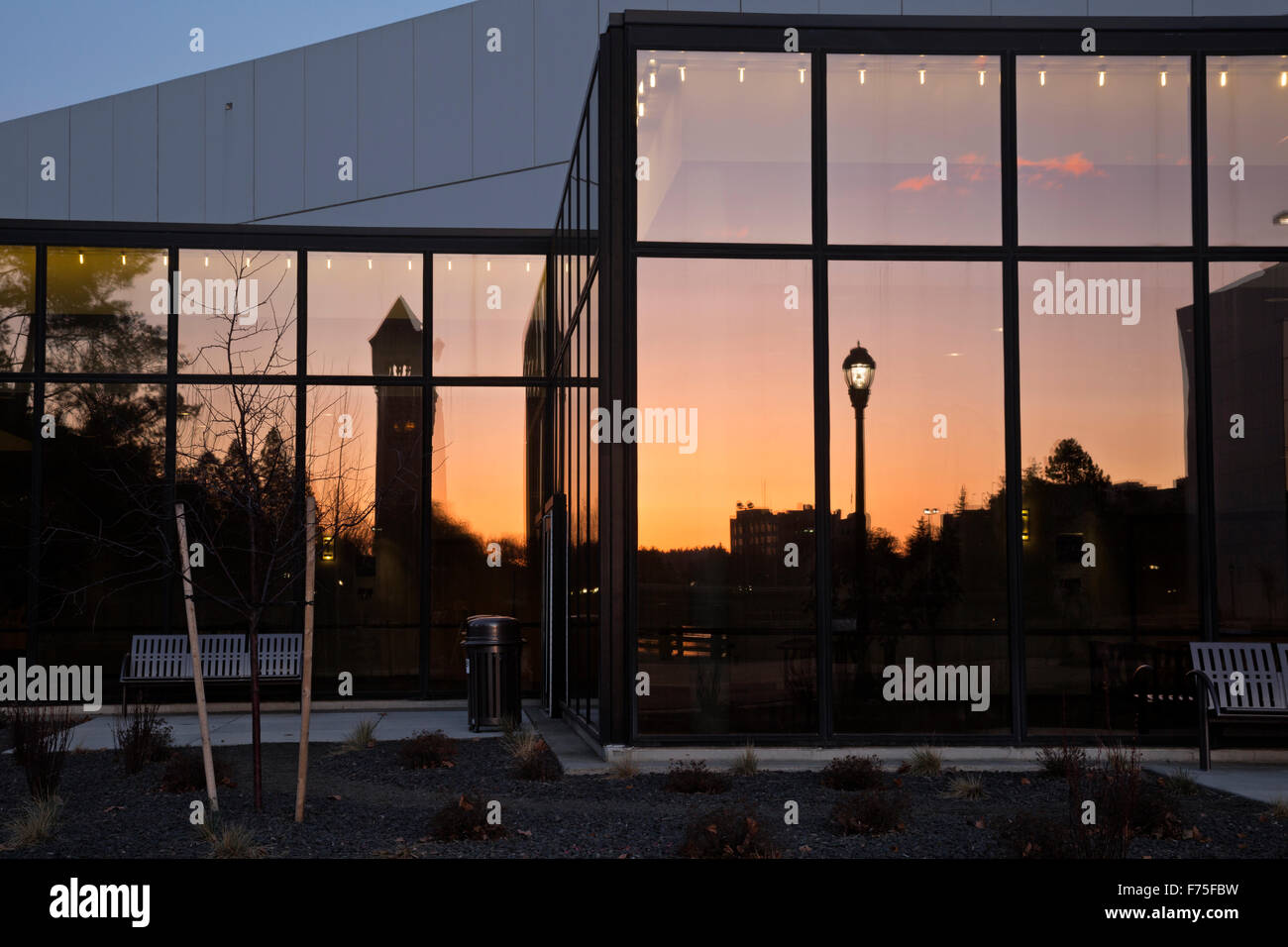 Lo Spokane Torre dell Orologio che riflettono al tramonto nelle finestre di vetro della Convention Center si trova in Riverside Park, Spokane. Foto Stock