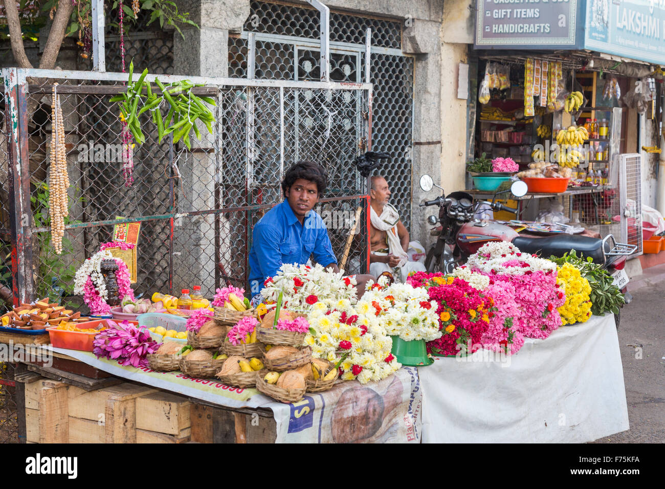 Venditore di fiori Vendita fiori religiosa per offerte votive al di fuori del tempio di Kapaleeswarar, un tempio di Shiva, Mylapore, Chennai, nello Stato del Tamil Nadu, India Foto Stock
