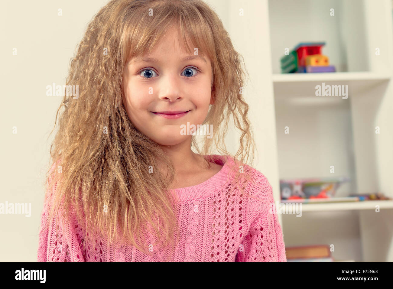 Ritratto di una bella sorridente bambina nella stanza dei bambini Foto Stock