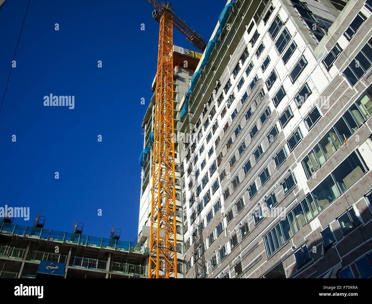 Una gru su un alto edificio sito Foto Stock