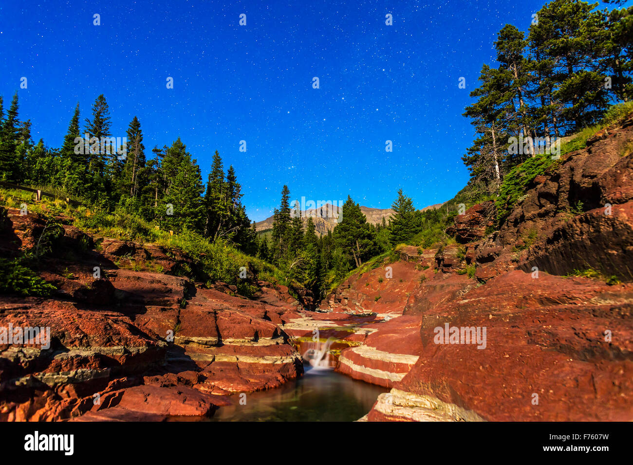 Cassiopeia e il nord di stelle sopra il Red Rock Canyon nel Parco Nazionale dei laghi di Waterton, Alberta, con illuminazione da una ceratura Foto Stock