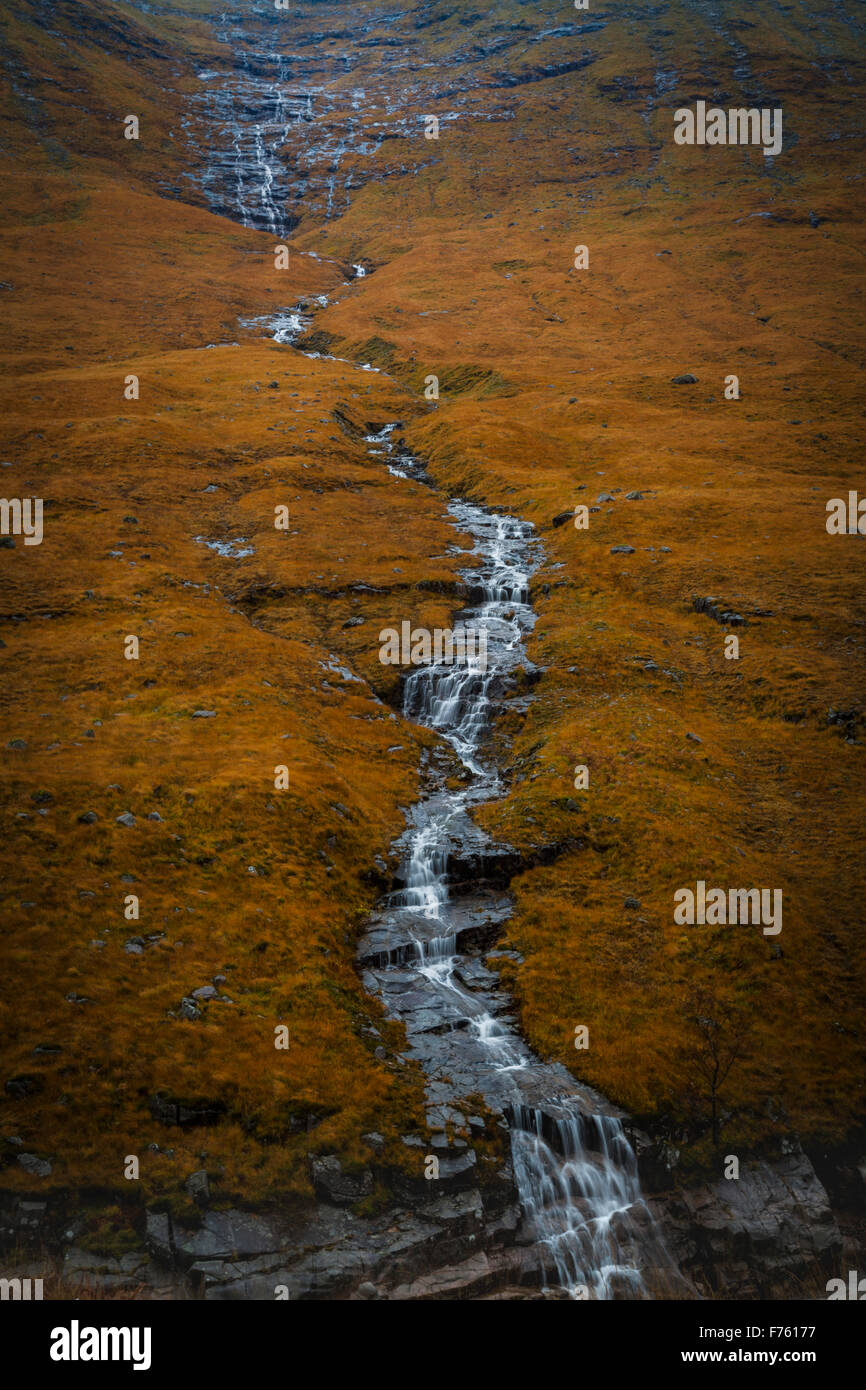 Lunga cascata sopra esposta sul granito bracken coperto hillside, autunno Scozia Scotland Foto Stock