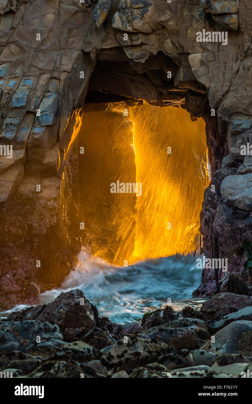 Julia Pfeiffer Burns State Park Arco Rock al tramonto con rottura sole attraverso saline. Immagini di fuoco. Foto Stock