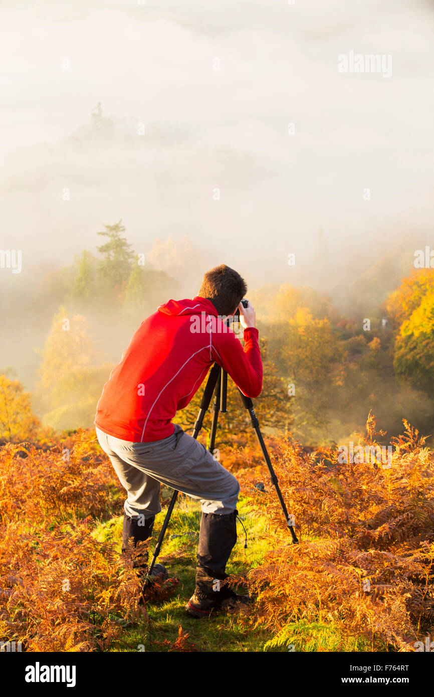 Nebbia a valle sul Lago di Windermere da Todd roccioso nel distretto del lago, Regno Unito all'alba con un fotografo in primo piano. Foto Stock