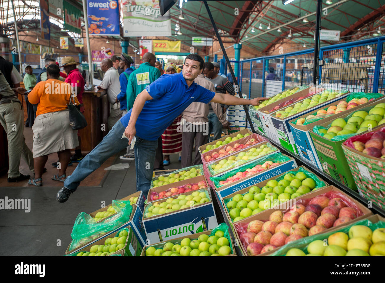 Uomo di raggiungere per le mele a Tshwane prodotti freschi di mercato in Sud Africa Foto Stock