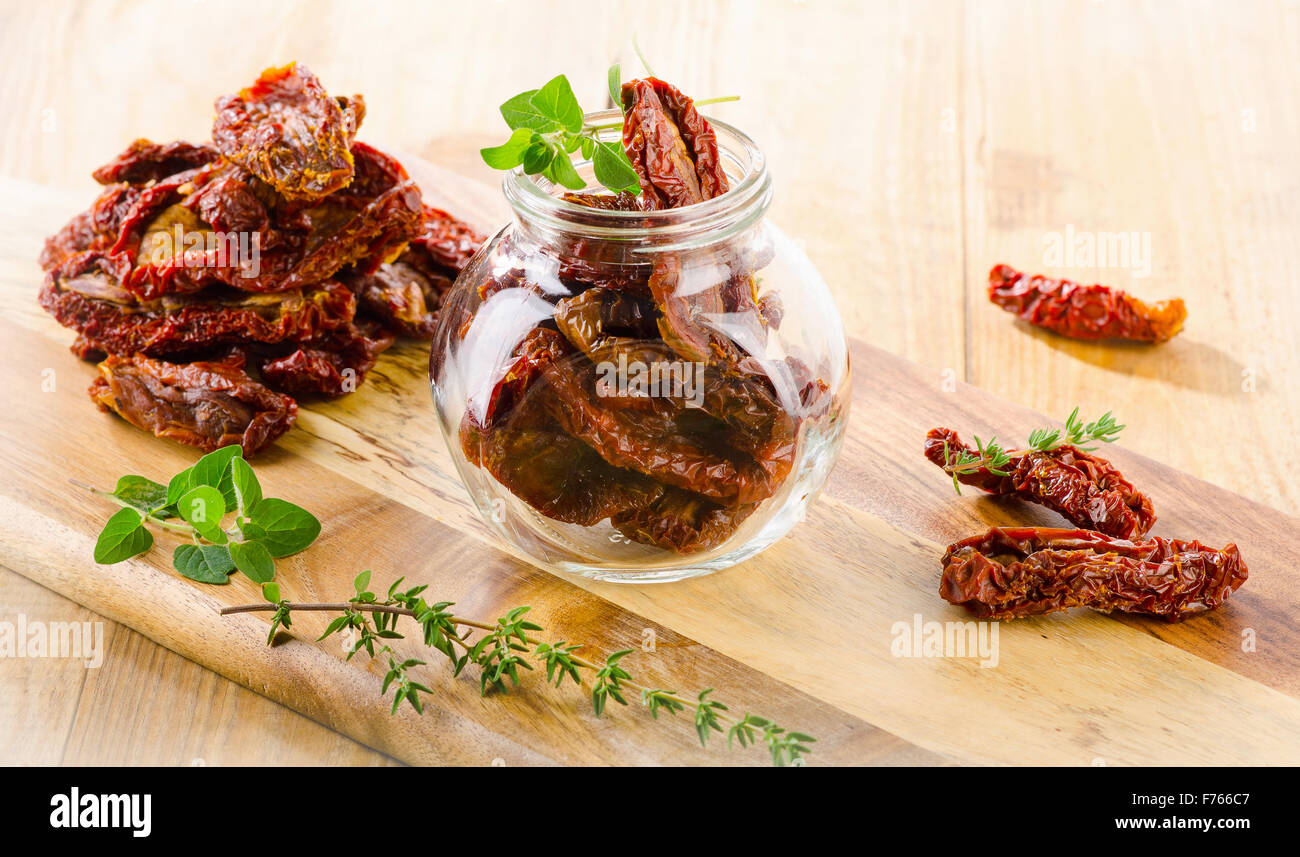 Sole italiano pomodori secchi in un vaso di vetro su un tavolo di legno. Messa a fuoco selettiva Foto Stock