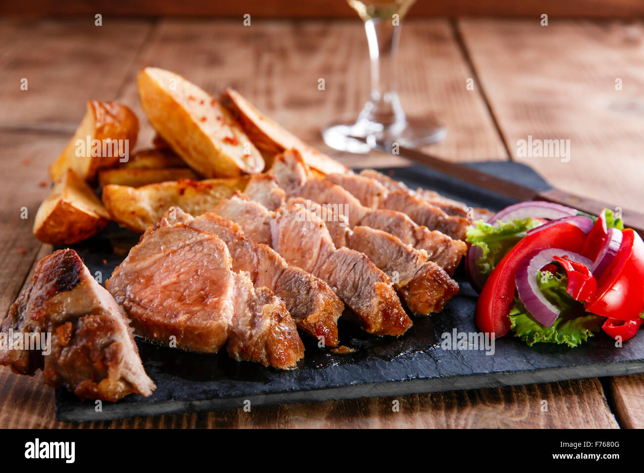 Fette di bistecca di carne di maiale con patate fritte Foto Stock