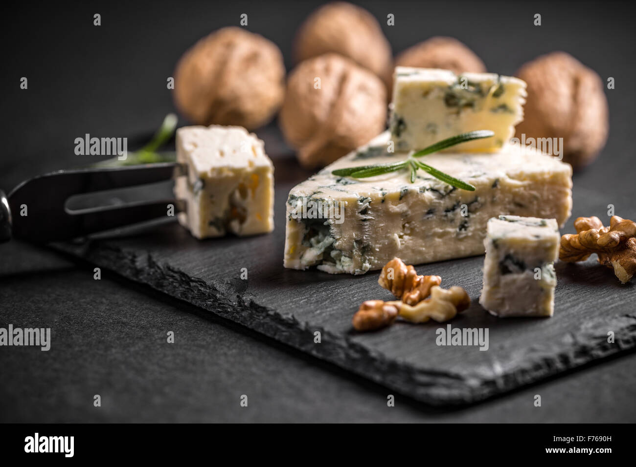 Gustoso formaggio blu con il dado sul buio superficie di ardesia Foto Stock