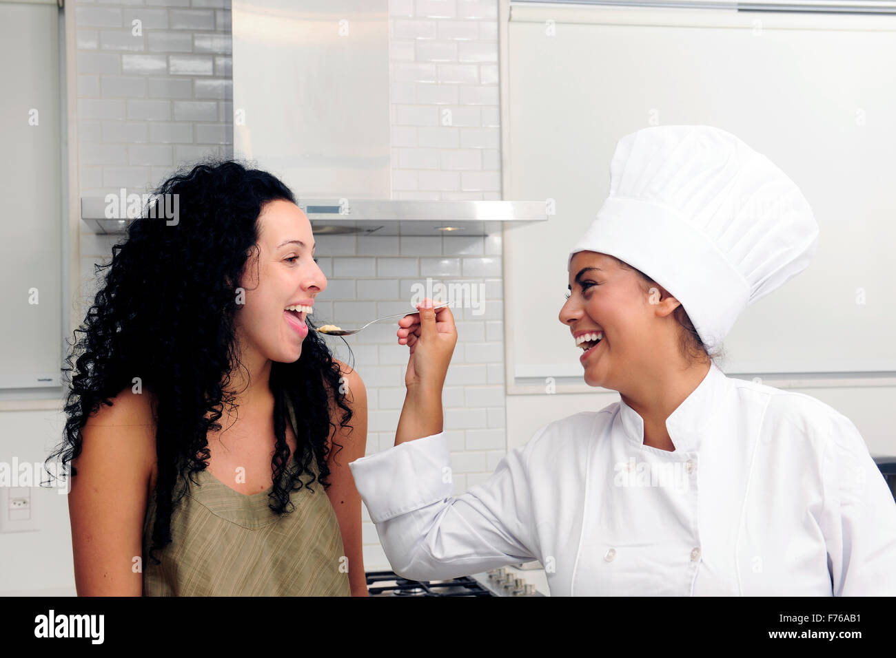 Corso di cucina: Chef che offre i suoi gustosi risotti su un cucchiaio per la degustazione Foto Stock