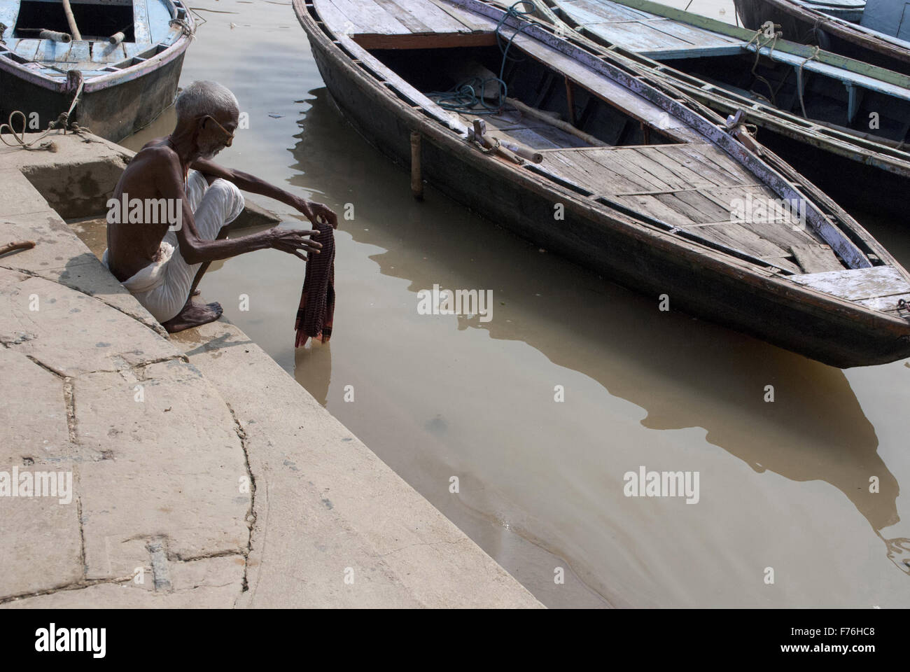 Il vecchio uomo lavaggio biancheria ganga river, Varanasi, Uttar Pradesh, India, Asia Foto Stock