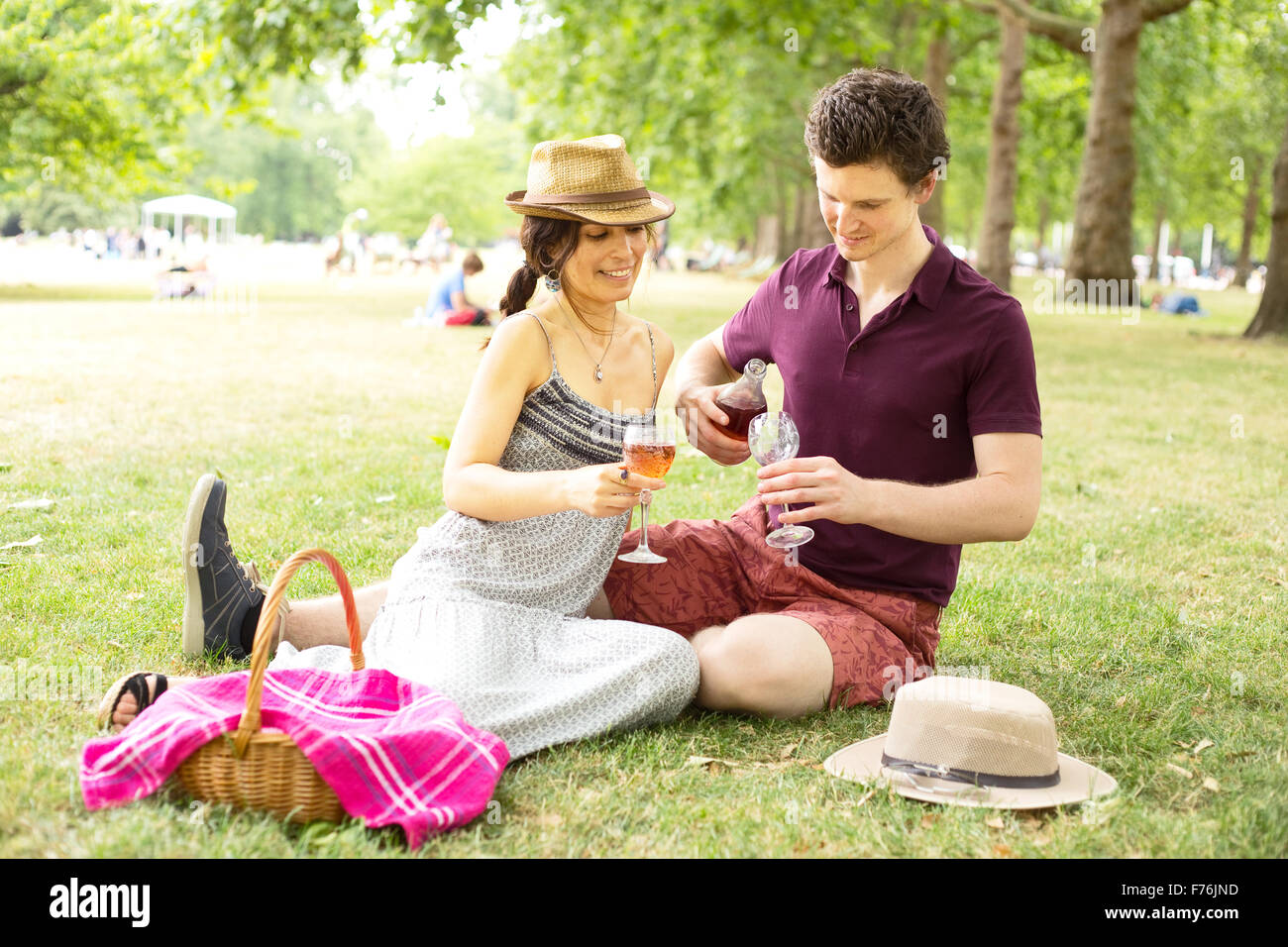 Coppia giovane nel parco godendo un picnic e un bicchiere di vino Foto Stock