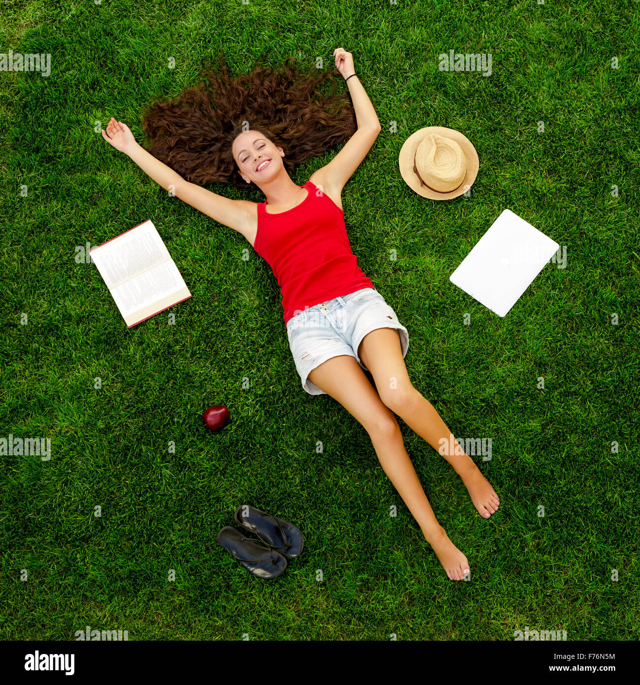 Bella e felice giovane donna sdraiati sull'erba Foto Stock