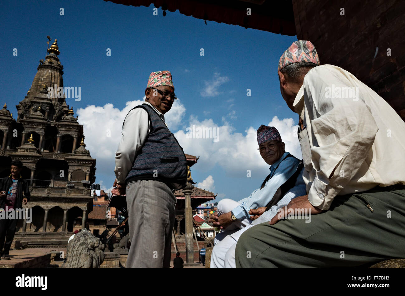 Vecchio nepalese gli uomini indossano abiti nepalese hanno piacevole chiacchierare con ogni altro a Patan Durbar Square, Krishna Mandir, Lalitpur Foto Stock