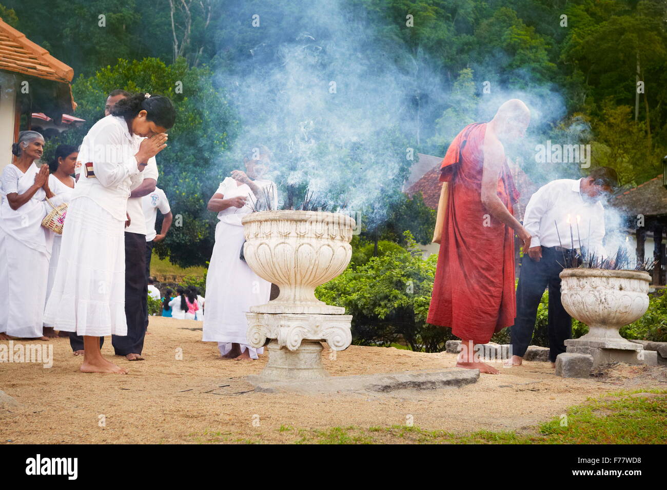 Sri Lanka, Kandy - Monaco accende incenso offerte nel tempio del Dente, Sri Dalada Maligawa, Patrimonio Mondiale dell UNESCO Foto Stock