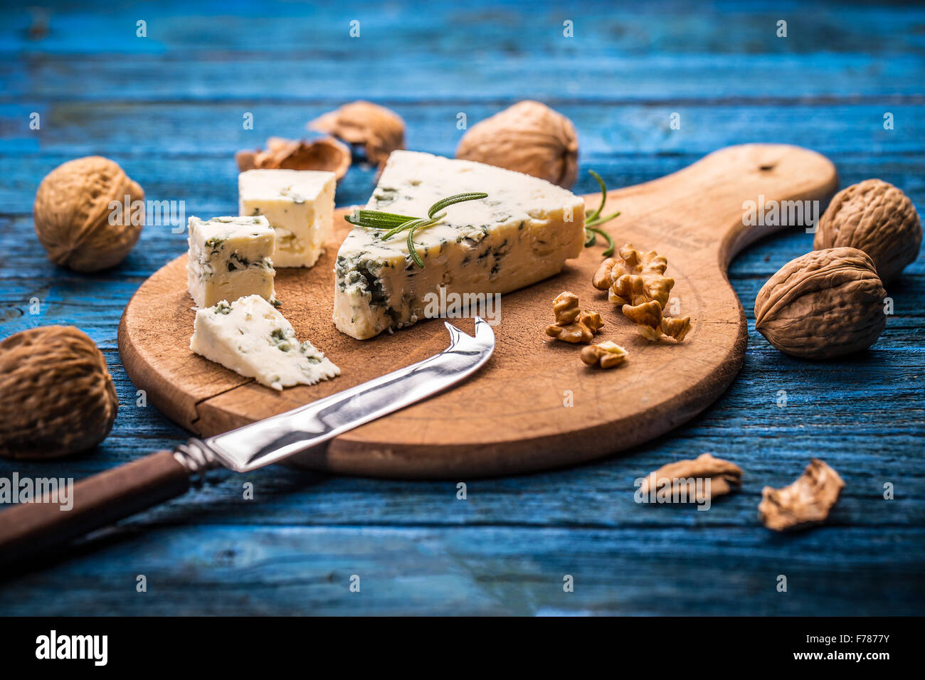 Formaggio blu con i dadi sul bordo di taglio Foto Stock